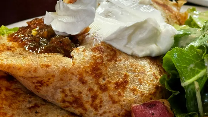 A white plate topped with a piece of bread and a salad